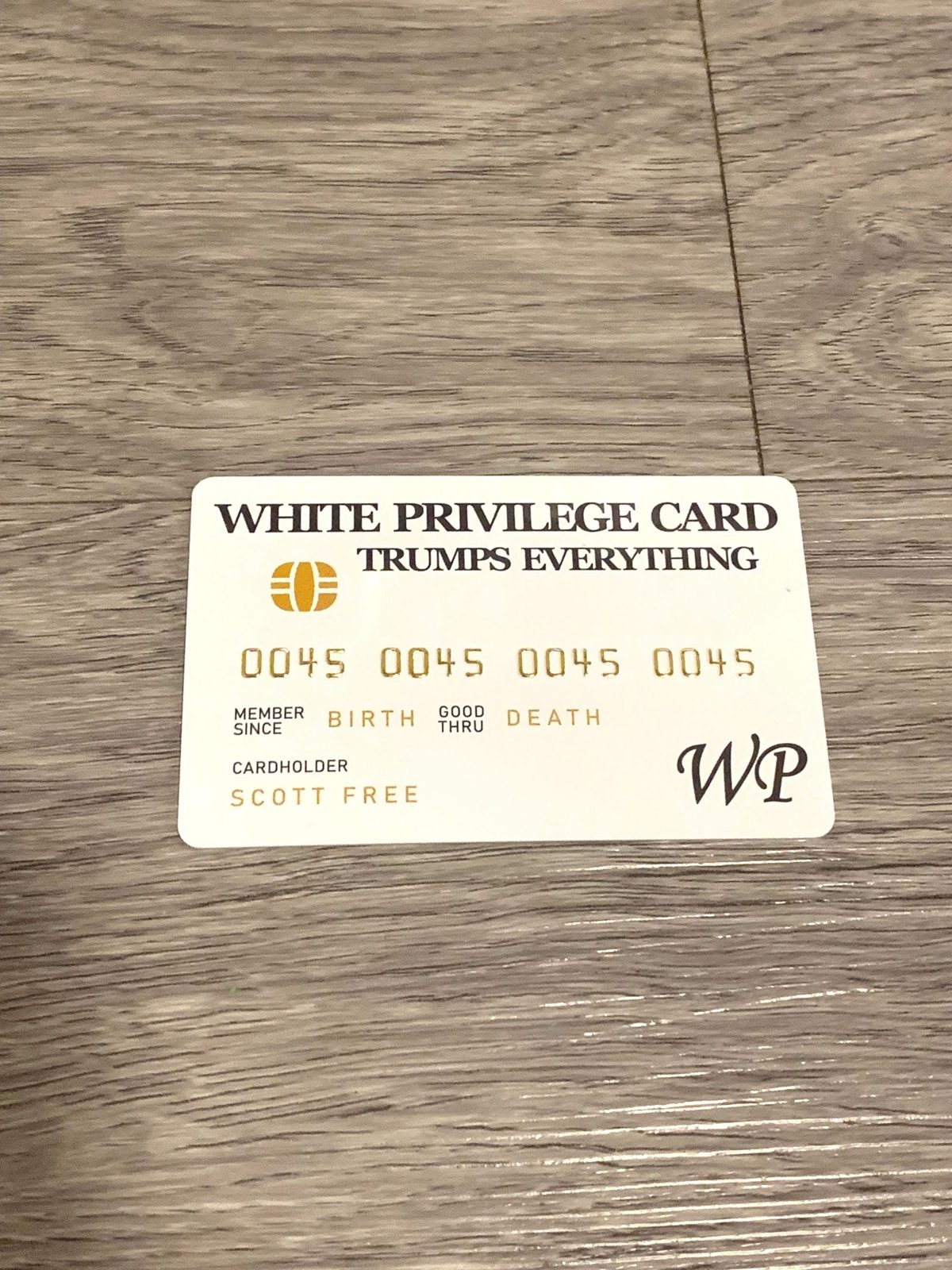 White Privilege Card on a wood floor